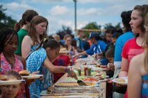 Families get food during a party for family members of deployed Airmen Aug. 12, 2016 at Ramstein Air Base, Germany. The event was put together for family members of deployed Airmen around the Kaiserslautern Military Community to get together and enjoy a variety of food and games. (U.S. Air Force photo/Airman 1st Class Lane T. Plummer)