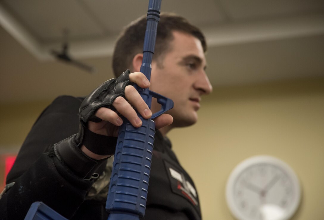 Tech. Sgt. Logan Ray, 11th Security Support Squadron assistant NCO in charge of training, holds an imitation M-16 weapon during an active shooter training at the Jacob E. Smart Building on Joint Base Andrews, Md., Aug. 17, 2016. The training, held by the 11th SSPTS, instructed attendees on how to react during an active shooter incident in specific office locations. Attendees also had the opportunity to implement the training they learned during an active shooter drill. (U.S. Air Force photo by Airman Gabrielle Spalding)