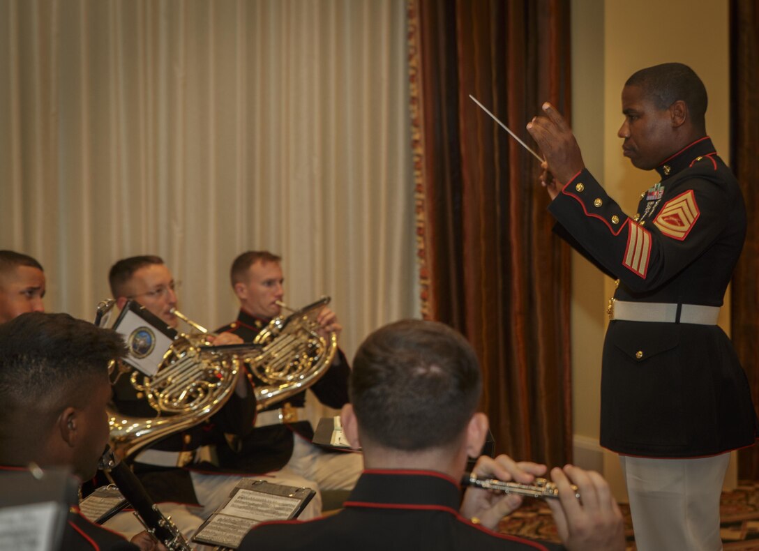 Gunnery Sgt. Justin A. Hauser (right), an enlisted conductor with Marine Corps Band New Orleans, leads the band in a rendition of “The Marines’ Hymn” during the 31st annual reunion and muster of the Marine Corps Mustang Association at the Astor Crowne Plaza French Quarter Hotel in New Orleans, Aug. 18, 2016. The theme of the evening event was the Marine Corps Reserve centennial celebration, which begins with events around the country later this month. (U.S. Marine Corps photo by Sgt. Ian Leones/Released)