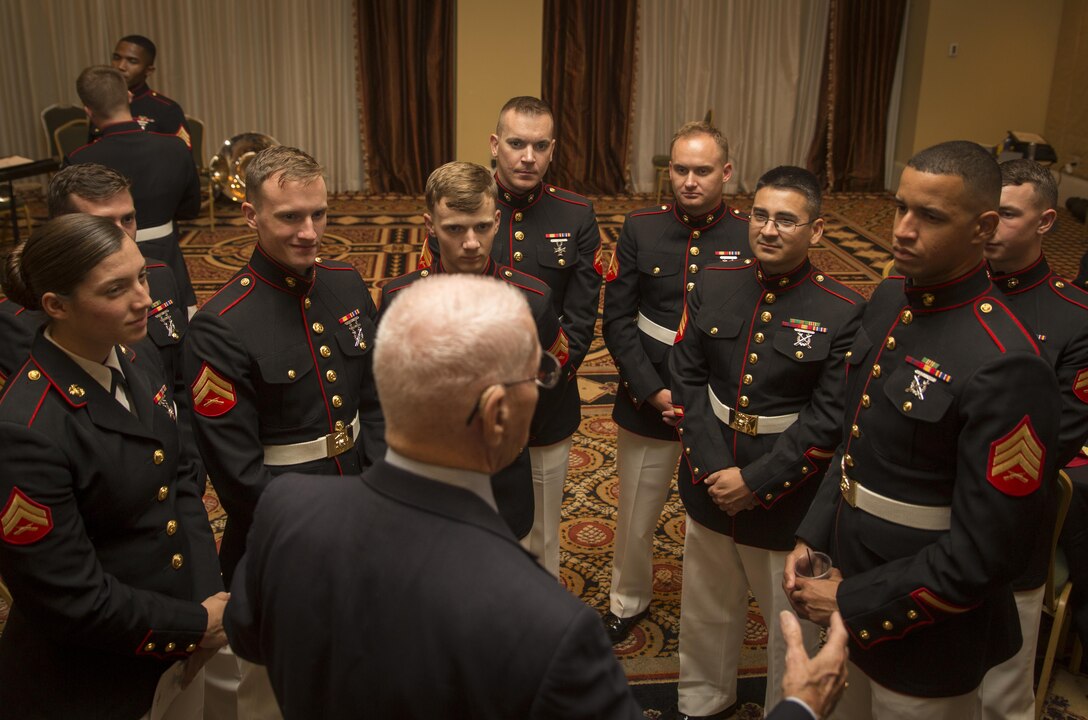 Members of Marine Corps Band New Orleans listen to stories from a retired Marine during the 31st annual reunion and muster of the Marine Corps Mustang Association at the Astor Crowne Plaza French Quarter Hotel in New Orleans, Aug. 18, 2016. The Mustang Association is comprised of officers from the Marine Corps officers and other military services who were enlisted prior to commissioning. Now in its 31st year of existence, the association continues to dedicate itself to the advocacy of professional development and encouragement for younger enlisted Marines. The evening event highlighted the centennial celebration of the Marine Corp Reserve, which begins at the end of the month. (Marine Corps photo by Sgt. Ian Leones/Released)