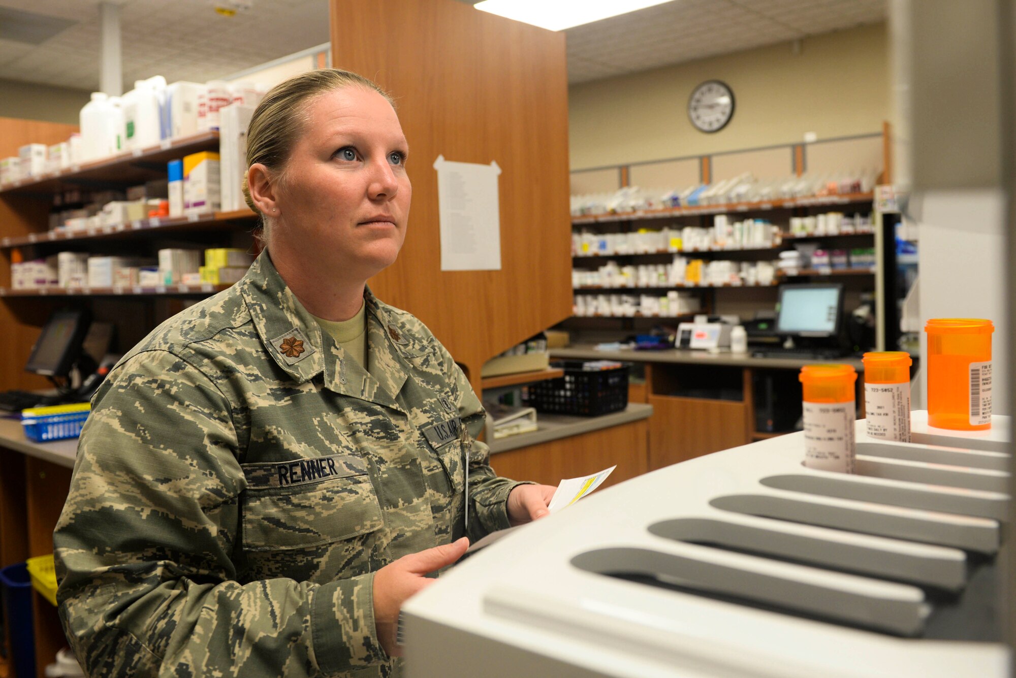 Maj. Brandy Renner, the chief pharmacy element assigned to the 5th Medical Support Squadron, confirms prescriptions at Minot Air Force Base, N.D., Aug. 17, 2016. This automated machine fills prescriptions while technicians check to ensure the correct medicine, correct dosage and correct number of pills are placed in the proper bottle. (U.S Air Force photo/Airman 1st Class Jessica Weissman)