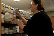 Marisa Dolbeare, a pharmacy technician assigned to the 5th Medical Group, checks expiration dates on medicine at the pharmacy clinic at Minot Air Force Base, N.D., Aug. 17, 2016. The pharmacy accepts electronic and paper prescriptions from downtown and on-base doctors. (U.S Air Force photo/Airman 1st Class Jessica Weissman)