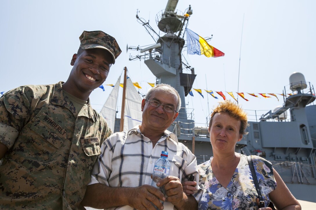 U.S. Marine Corps Cpl. Clarence Wimberly a U.S. Marine with the Black Sea Rotational Force, poses with a Romanian couple attending Open Gates Day at the Naval Port of Constanța,  Romania, Aug. 6, 2016. Black Sea Rotational Force is an annual multilateral security cooperation activity between the U.S. Marine Corps and partner nations in the Black Sea, Balkan and Caucasus regions designed to enhance participants’ collective professional military capacity, promote regional stability and build enduring relationships with partner nations.  (U.S. Marine Corps photo by Cpl. Kyle C. Talbot)