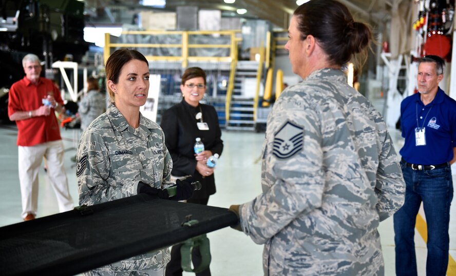 Tech. Sgt. Kristi DiMarco and Master Sgt. Denise Hunt, both with the 932nd Aeromedical Staging Squadron, demonstrate liter patient movements during the Belle-Scott event Aug. 18, 2016 at the 126th Air Refueling Wing hangar, Scott Air Force Base, Illinois. The Belle-Scott Committee is comprised of local community leaders who meet with Scott Air Force Base officials on a recurring basis. (U.S. Air Force photo by Christopher Parr)
