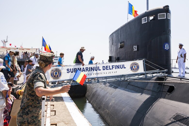 United States Marine Corps Cpl. Colleen Moran a Civil Affairs Marine with the Black Sea Rotational Force, watches as locals board the Definul or Dolphin, a Romanian submarine docked for tours on Open Gates Day at the Naval Port of Constanța, Romania, Aug. 6, 2016.  Black Sea Rotational Force is an annual multilateral security cooperation activity between the U.S. Marine Corps and partner nations in the Black Sea, Balkan and Caucasus regions designed to enhance participants’ collective professional military capacity, promote regional stability and build enduring relationships with partner nations. (U.S. Marine Corps photo by Cpl. Kyle C. Talbot)