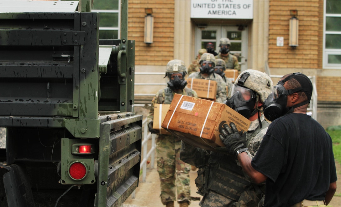 Soldiers with Echo Forward Support Company, 326th Brigade Engineer Battalion, 1st Brigade Combat Team, 101st Airborne Division, Fort Campbell, Kentucky, conduct a simulated supply pickup operation during a Chemical, Biological, Radiological and Nuclear defense training exercise at Muscatatuck Urban Training Center, Indiana, Aug. 14, 2016. Company E leaders used the exercise to introduce their Soldiers to a new piece of equipment, the M50 – Joint Service General Purpose Mask, which replaced the US Military’s M40 Field Protective Mask. (US Army Reserve Photo by Sgt. Quentin Johnson, 211th MPAD/Released)