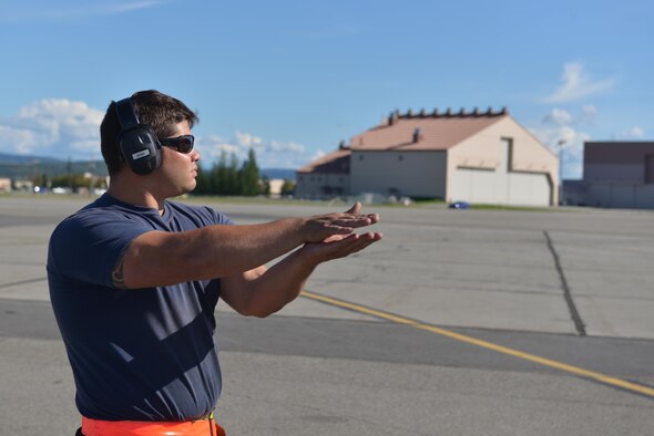 Royal Canadian Air Force Cpl. Zach McCann, an aviation systems technician assigned to the 409th Tactical Fighter Squadron out of Canadian Forces Base Cold Lake, Alberta, communicates with a pilot in a CF-18 Hornet aircraft through hand signals during RED FLAG-Alaska 16-3, at Eielson Air Force Base, Alaska, Aug. 18, 2016. RF-A allows joint and international units to sharpen their combat skills by flying simulated combat sorties in a realistic threat environment. (U.S. Air Force photo by Airman Isaac Johnson)