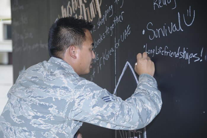 Senior Airman Timothy V. Bui, 12th Aircraft Maintenance Unit avionics specialist, writes on a chalkboard Aug. 17, 2016, at Beale Air Force Base, California. The chalkboard was part of a resiliency day event for participants to write and share their deployment experiences. (U.S. Air Force photo by Senior Airman Tara R. Abrahams)
