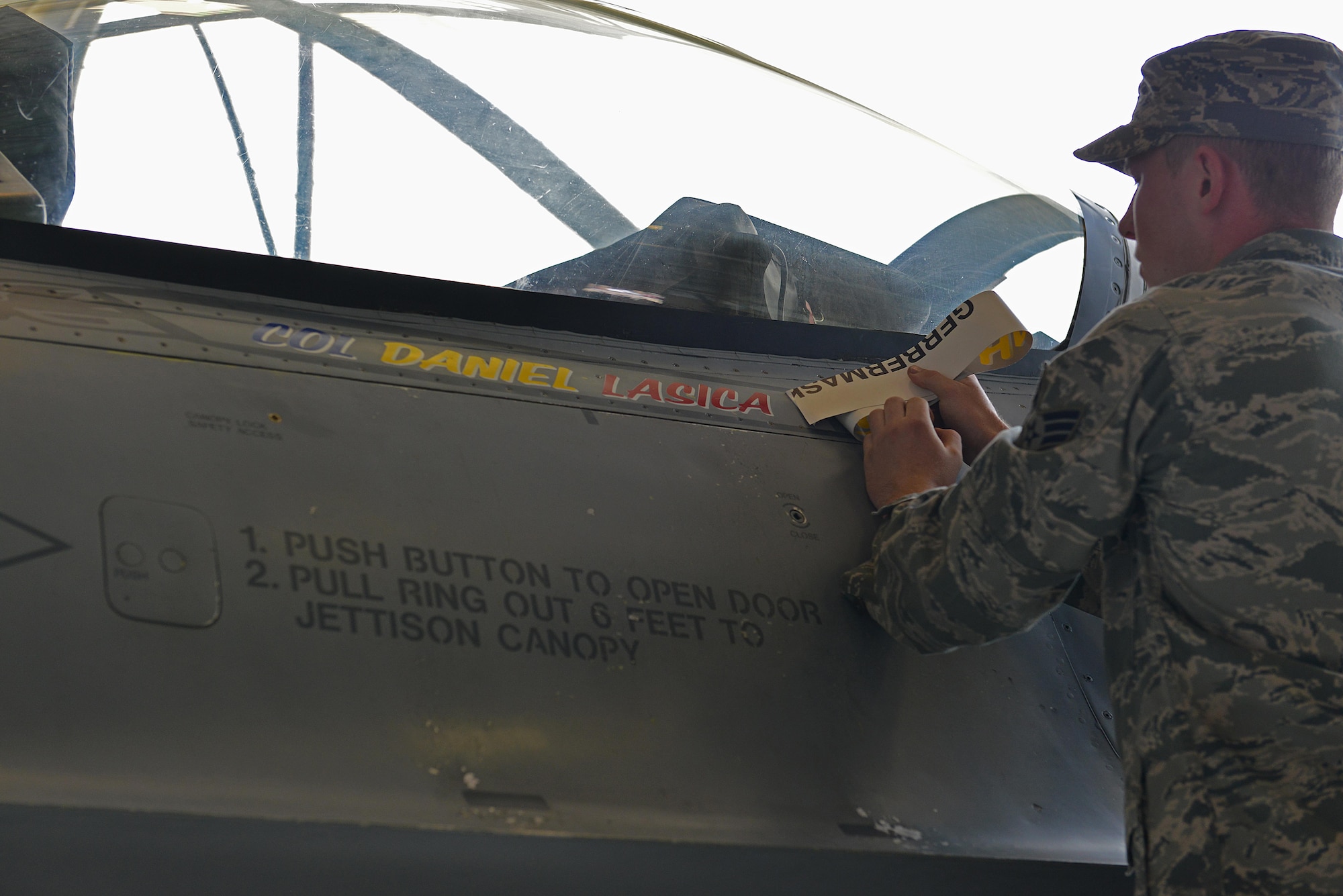 U.S. Air Force Senior Airman Nicholas Snyder, 20th Aircraft Maintenance Squadron tactical aircraft maintainer reveals the name of Col. Daniel Lasica, incoming 20th Fighter Wing commander, on an F-16CM Fighting Falcon at Shaw Air Force Base, S.C., Aug. 19, 2016. As commander of the 20th FW, Lasica will lead the wing in its mission of maintaining readiness to deploy and employ combat forces in support of operational wartime requirements worldwide. (U.S. Air Force photo by Airman 1st Class Destinee Sweeney)