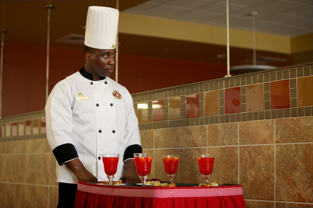 Sgt. Theius Dalton anxiously waits to be judged for his culinary expertise during the Headquarters and Headquarters Squadron’s Chef of the Quarter Competition aboard Marine Corps Air Station Cherry Point, N.C., Aug. 18, 2016. The quarterly competition tests food service specialists on the taste of their food, plate display, table appearance and culinary knowledge based on the anniversary theme they were given. Dalton is a food service specialist with H&HS. (U.S. Marine Corps photo by Cpl. Jason Jimenez/Released)