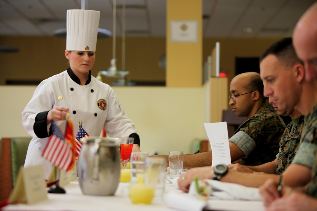 Sgt. Megan McGuire presents her food to the judges of the Headquarters and Headquarters Squadron’s Chef of the Quarter Competition aboard Marine Corps Air Station Cherry Point, N.C., Aug. 18, 2016. The quarterly competition tests food service specialists on the taste of their food, plate display, table appearance and culinary knowledge based on the anniversary theme they were given.  McGuire is a food service specialist with H&HS. (U.S. Marine Corps photo by Cpl. Jason Jimenez/Released)