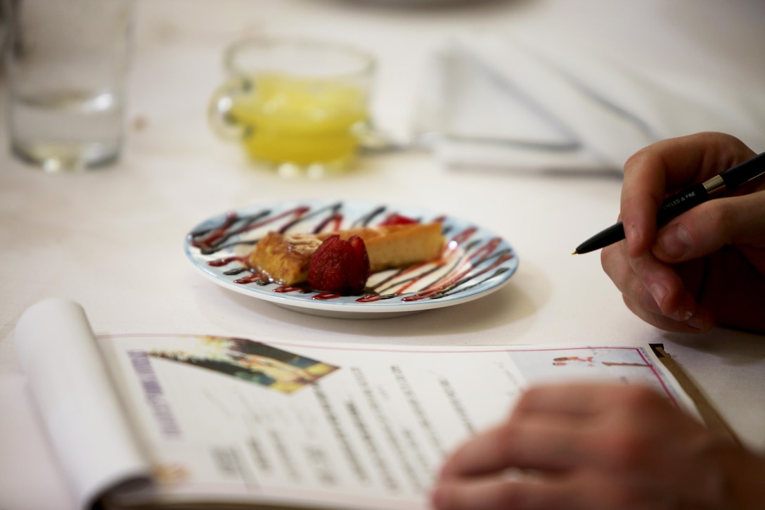 A dessert item created by Cpl. Marisela Olibares is judged by Lt. Col. Jason Donovan during the Headquarters and Headquarters Squadron’s Chef of the Quarter Competition aboard Marine Corps Air Station Cherry Point, N.C., Aug. 18, 2016. The quarterly competition tests food service specialists on the taste of their food, plate display, table appearance and culinary knowledge based on the anniversary theme they were given. Olibares is a food service specialist with H&HS and Donovan, a judge during the competition, is the commanding officer for H&HS and Olibares is a food service specialist with H&HS.  (U.S. Marine Corps photo by Cpl. Jason Jimenez/Released)