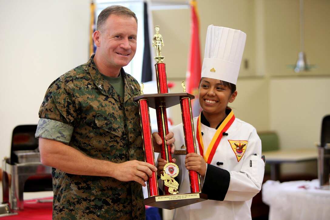 Col. Todd Ferry, left, poses for a photo with Cpl. Marisela Olibares after she won the Headquarters and Headquarters Squadron’s Chef of the Quarter Competition aboard Marine Corps Air Station Cherry Point, N.C., Aug. 18, 2016. The quarterly competition tests food service specialists on the taste of their food, plate display, table appearance and culinary knowledge based on the anniversary theme they were given. The winner is allowed the opportunity to compete against previous chef of the quarter winners to in September during the Chef of the Year competition. Ferry is the commanding officer for MCAS Cherry Point and Olibares is a food service specialist with H&HS. (U.S. Marine Corps photo by Cpl. Jason Jimenez/Released)