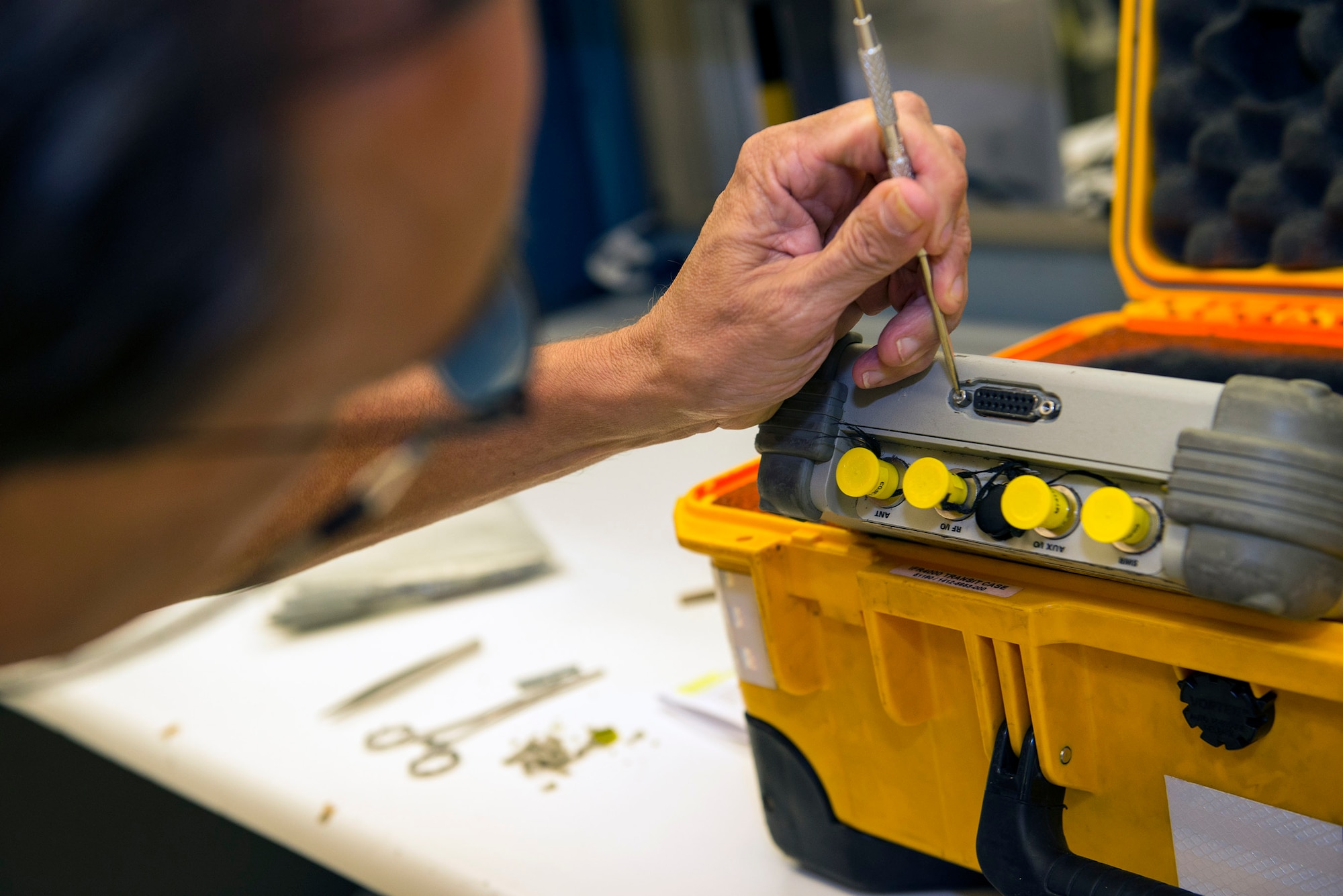 Walter Truax, 23d Component Maintenance Squadron precision measurement equipment laboratory site manager, removes debris from electronic wiring, Aug. 17, 2016, at Moody Air Force Base, Ga. Truax was a former PMEL Airman who retired as a chief master sergeant and chose to reintegrate into the Air Force as a contractor to support the PME mission for Moody AFB and the 125th Fighter Wing, Florida National Guard. (U.S. Air Force photo by Airman 1st Class Greg Nash) 