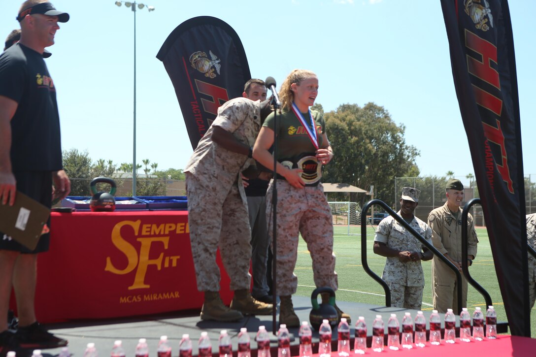 Sgt. Maj. Ronald Green, the Sgt. Maj. of the Marine Corps, places a championship belt on Sgt. Calie Jacobsen, the top female competitor  of the Tactical Athlete The competition was a part of the Marine Corps’ High Intensity Tactical Training program and tested the strengths and abilities of Marines from different installations around the Corps. (U.S. Marine Corps photo by Pfc. Liah Kitchen/Released)