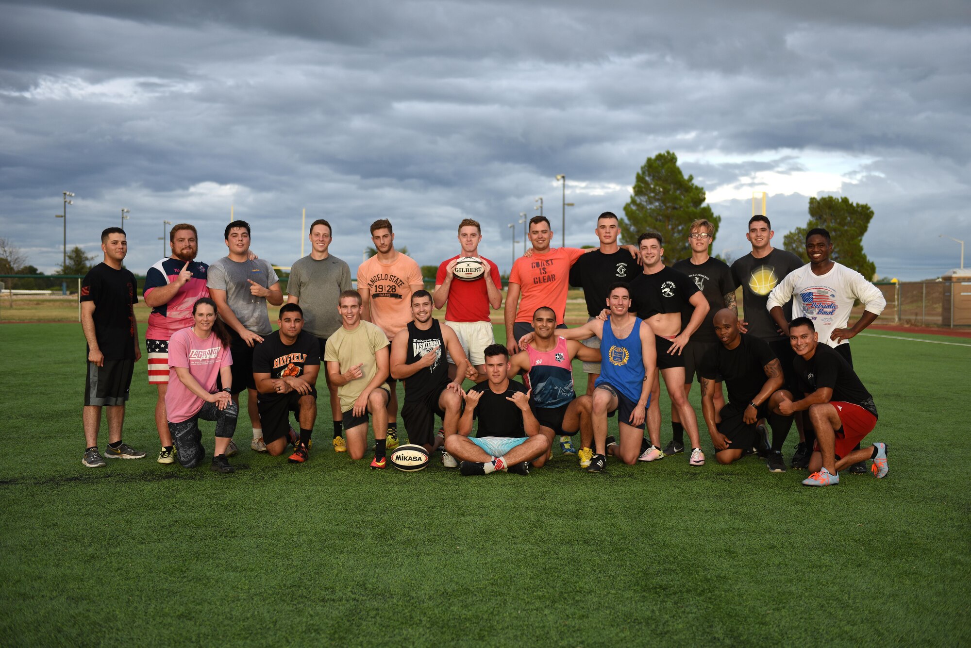 Rugby club members pose on the base softball field on Goodfellow Air Force Base, Texas, Aug. 17, 2016. The club includes permanent party, and students from multiple branches of service and even civilians from Angelo State University. (U.S.  Air Force photo by Airman 1st Class Caelynn Ferguson/Released)