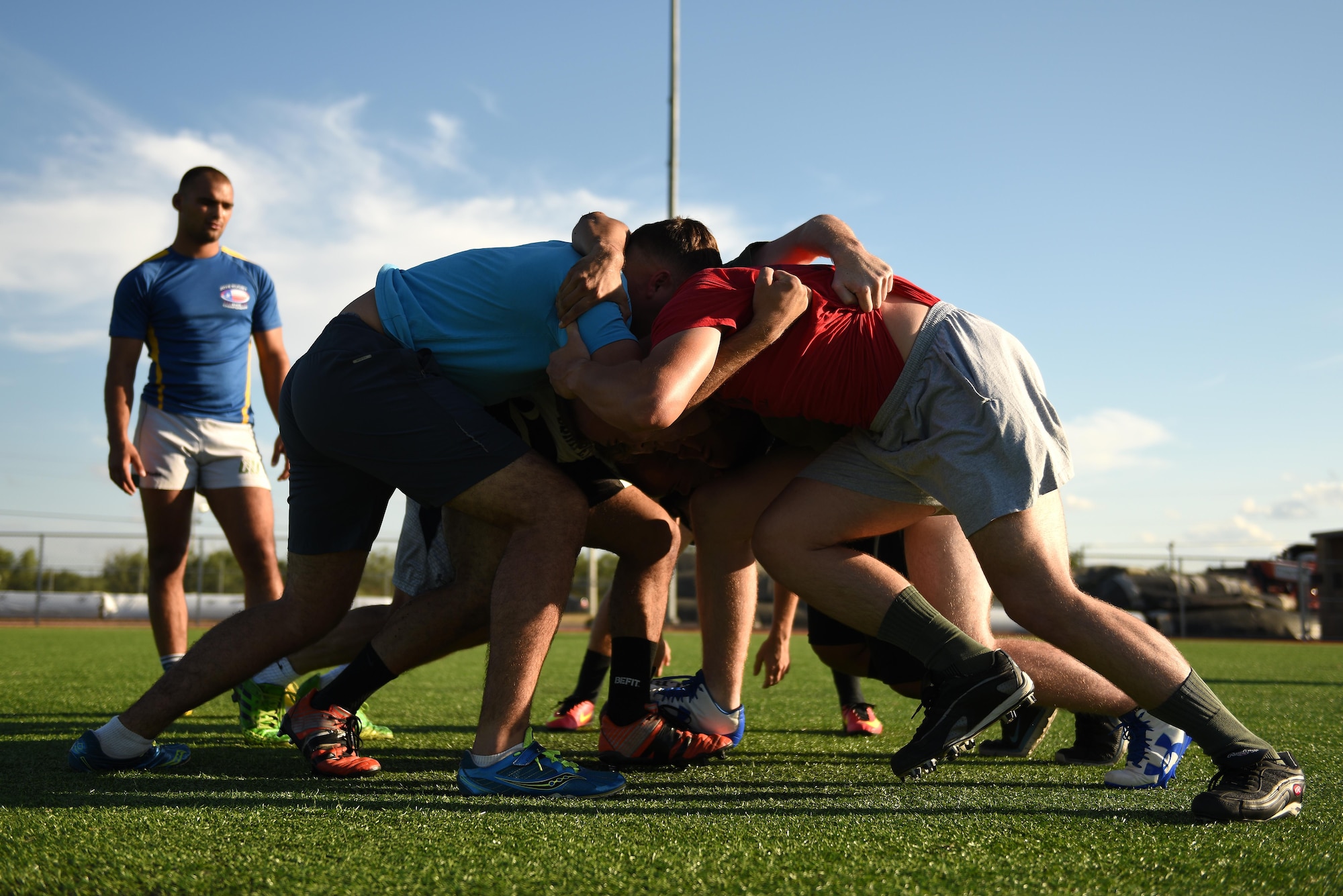 Rugby club members perform a ‘scrum’ on the base softball field on Goodfellow Air Force Base, Texas, Aug. 15, 2016. A scrum is a method of restarting play by packing teammates together for possession of the ball. (U.S. Air Force photo by Airman 1st Class Caelynn Ferguson/Released)