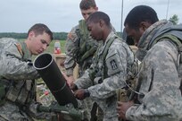 CAMP ATTERBURY, Ind. – (L to R) Spc. Carney, Pvt. Conway, Spc. Lowe, and Pvt. Parker-Clark assigned to Indiana’s 2nd Battalion, 151st Infantry Regiment (Indiana National Guard) inspect their 120 mm mortar for a final time before conducting a live fire exercise as part of their three week annual training.  (Photo by SGT Raymond Maldonado, 206th Broadcast Operations Detachment)