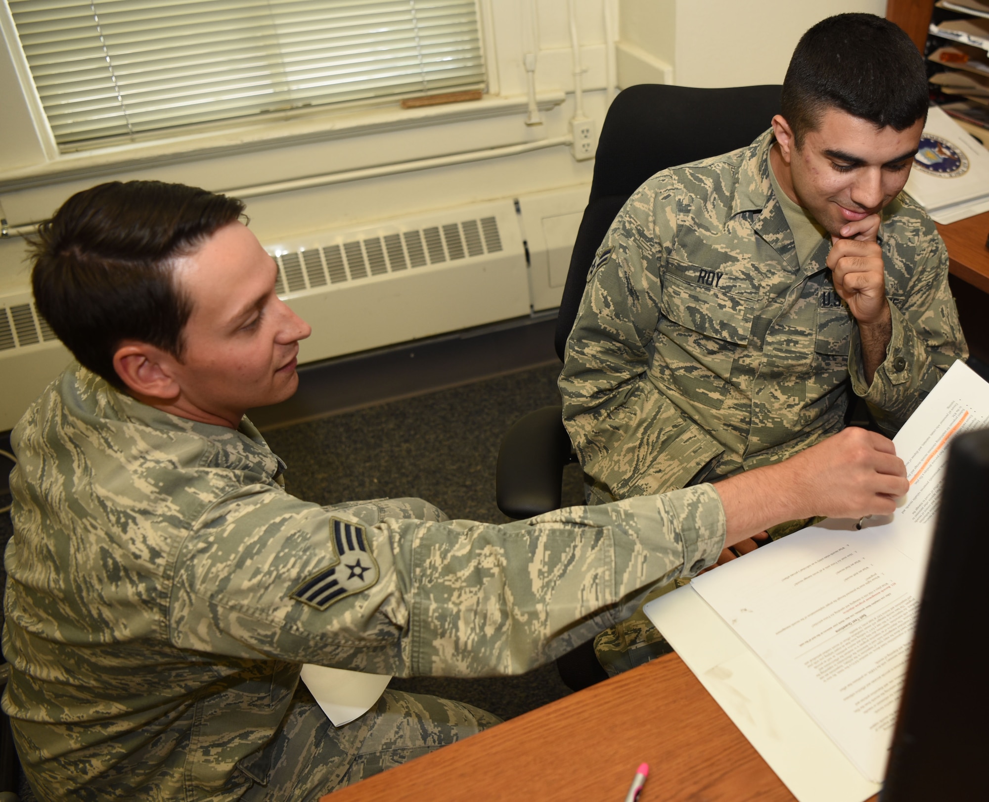 Senior Airman Cody Martin, 90th Communications Squadron cybersecurity technician, assists Airman 1st Class Jeremy Roy with his career development course work. Helping with CDCs is one way Martin supervises and helps Airmen to progress. (U.S. Air Force photo by Airman 1st Class Breanna Carter)