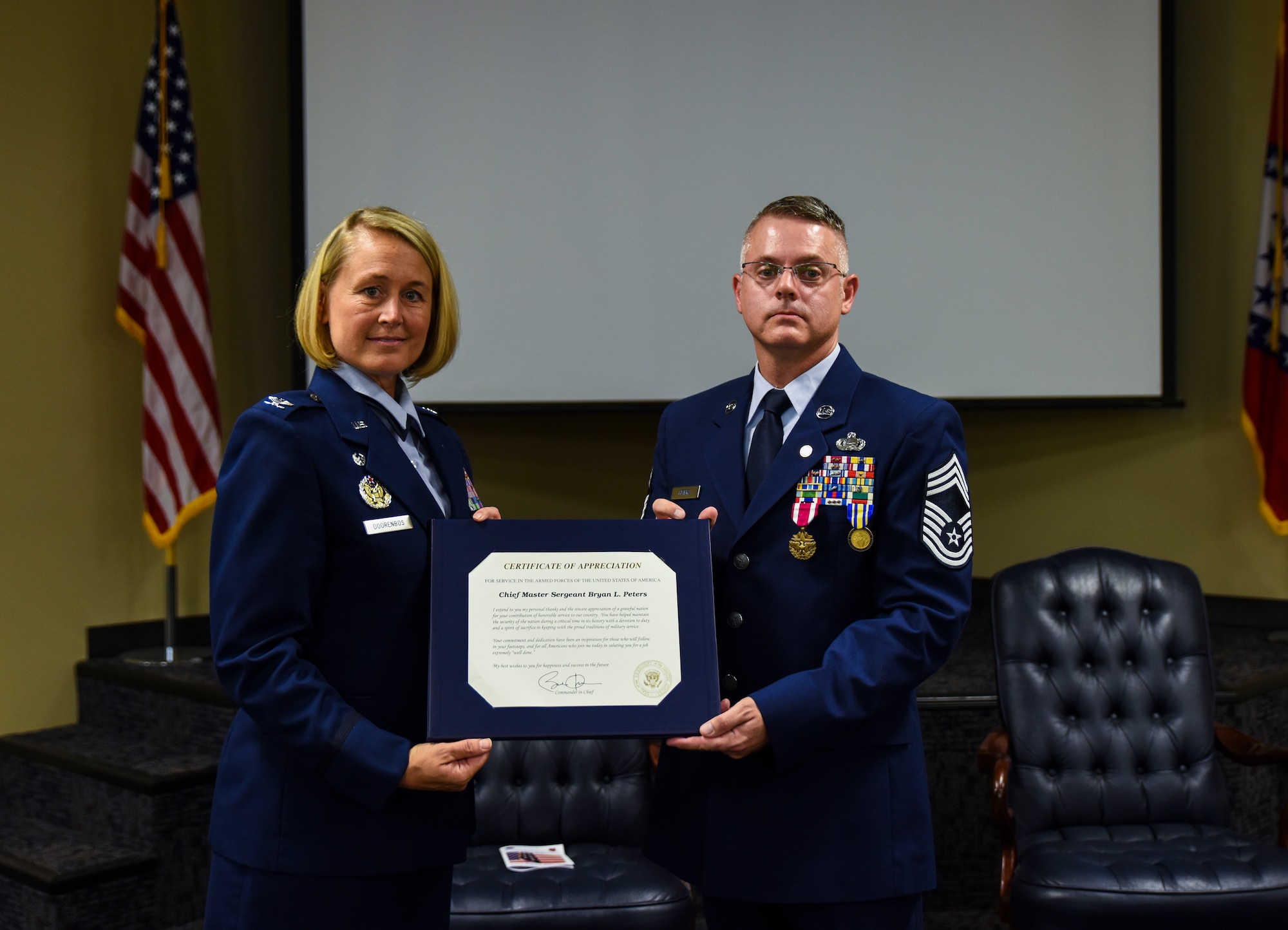 Col. Bobbi Doorenbos, 188th Wing commander, presents Chief Master Sgt. Bryan Peters, 188th Force Support Squadron supervisor, a Certificate of Appreciation from Barack Obama, commander in chief, Aug. 7, 2016, during Peters’ retirement ceremony at Ebbing Air National Guard Base, Fort Smith, Ark. Peters has served in the Air National Guard for over 24 years, all with the 188th Wing. (U.S. Air National Guard photo by Senior Airman Cody Martin)