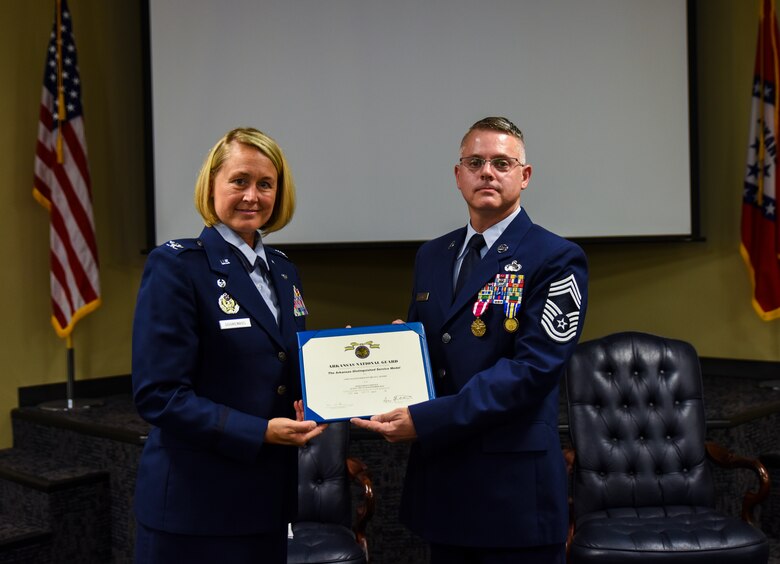 Col. Bobbi Doorenbos, 188th Wing commander, presents Chief Master Sgt. Bryan Peters, 188th Force Support Squadron supervisor, the Arkansas Distinguished Service Medal Aug. 7, 2016, during Peters’ retirement ceremony at Ebbing Air National Guard Base, Fort Smith, Ark. Peters has served in the Air National Guard for over 24 years, all with the 188th Wing. (U.S. Air National Guard photo by Senior Airman Cody Martin)