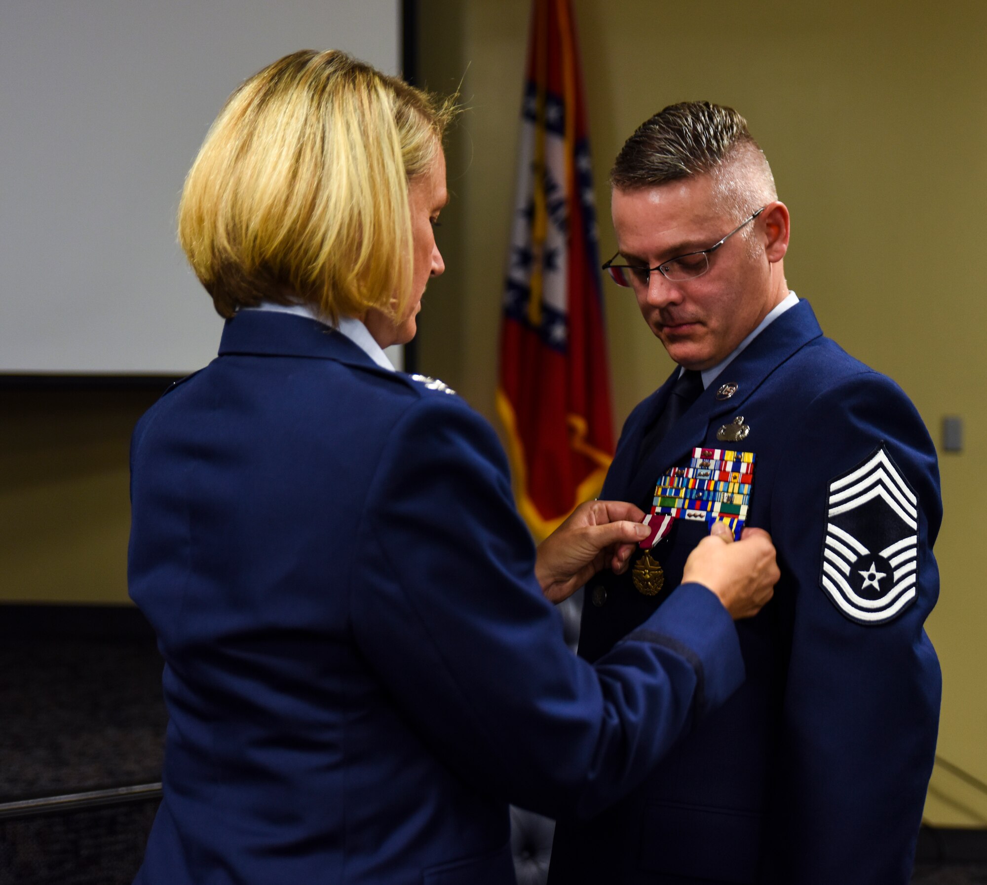 Col. Bobbi Doorenbos, 188th Wing commander, pins the Arkansas Distinguished Service Medal on Chief Master Sgt. Bryan Peters, 188th Force Support Squadron supervisor, Aug. 7, 2016, during Peters’ retirement ceremony at Ebbing Air National Guard Base, Fort Smith, Ark. Peters has served in the Air National Guard for over 24 years, all with the 188th Wing. (U.S. Air National Guard photo by Senior Airman Cody Martin)