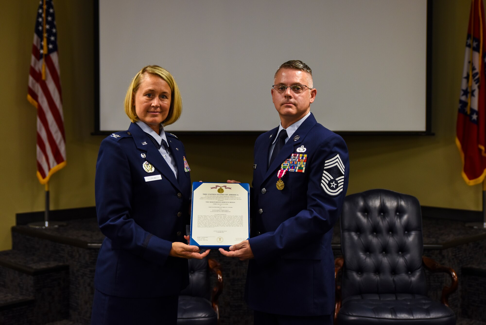 Col. Bobbi Doorenbos, 188th Wing commander, presents Chief Master Sgt. Bryan Peters, 188th Force Support Squadron supervisor, the Meritorious Service Medal Aug. 7, 2016, during Peters’ retirement ceremony at Ebbing Air National Guard Base, Fort Smith, Ark. Peters has served in the Air National Guard for over 24 years, all with the 188th Wing. (U.S. Air National Guard photo by Senior Airman Cody Martin)