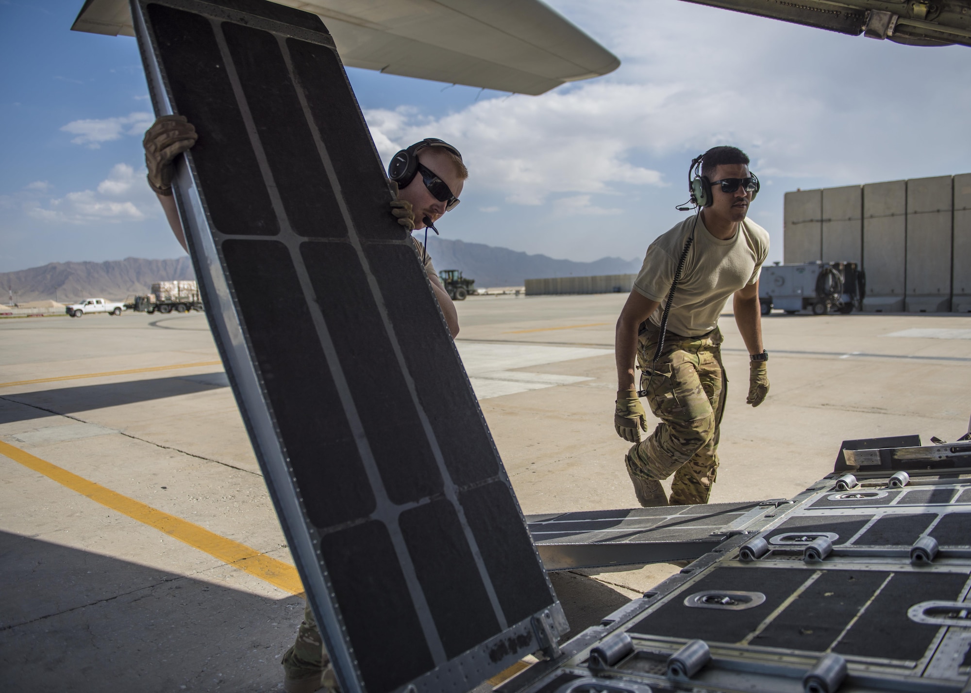 Staff Sgt. Dallion Richards (right) and Senior Airman Andrew Garrett (left), 774th Expeditionary Airlift Squadron loadmaster, lower the cargo vehicle ramps, Bagram Airfield, Afghanistan, Aug. 19, 2016. As loadmasters, Richards and Garrett ensure that cargo and personnel are properly loaded. (U.S. Air Force photo by Senior Airman Justyn M. Freeman)