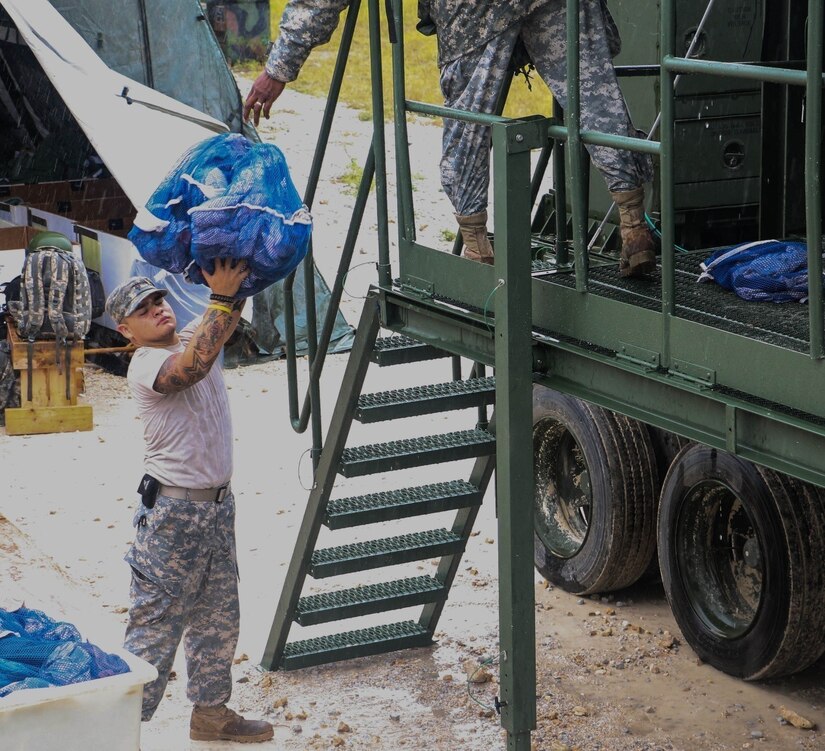 FORT HOOD, Texas. – U.S. Army Reserve Solider Spc. Martin Benavides, of San Antonio, Texas, passes laundry bundles to be placed in the Laundry Advance System, during annual training.  Spc. Benavides is part of the 340th Quartermaster Company out of Fort Sam Houston and conducting annual training at Fort Hood, Texas, Aug. 6 - 26, 2016.  (U.S. Army Reserve Photo by Sgt. Michael Adetula, 206th BOD)