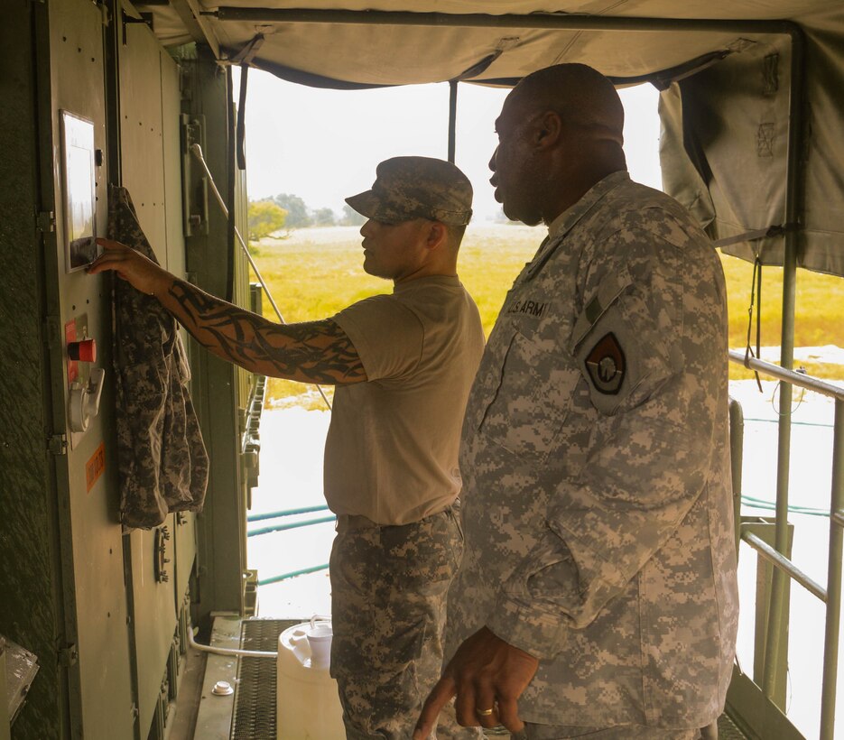 FORT HOOD, Texas – Sgt. 1st Class Julian Crawford of the 340th Quartermaster Company provides training to unit member Spc. Martin Benavides, on Aug. 16, 2016, his first day working with the laundry advance system.  (U.S. Army Reserve photo by Sgt. Michael Adetula/Released)