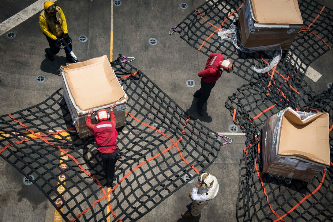 Sailors and Marines move pallets of supplies during a replenishment-at-sea on the USS San Antonio in the Gulf of Aden, Aug. 15, 2016. The Antonio is deployed with the Wasp Amphibious Ready Group to support maritime security operations and theater security cooperation efforts in the U.S. 5th Fleet area of operations. Navy photo by Petty Officer 2nd Class Adam Austin