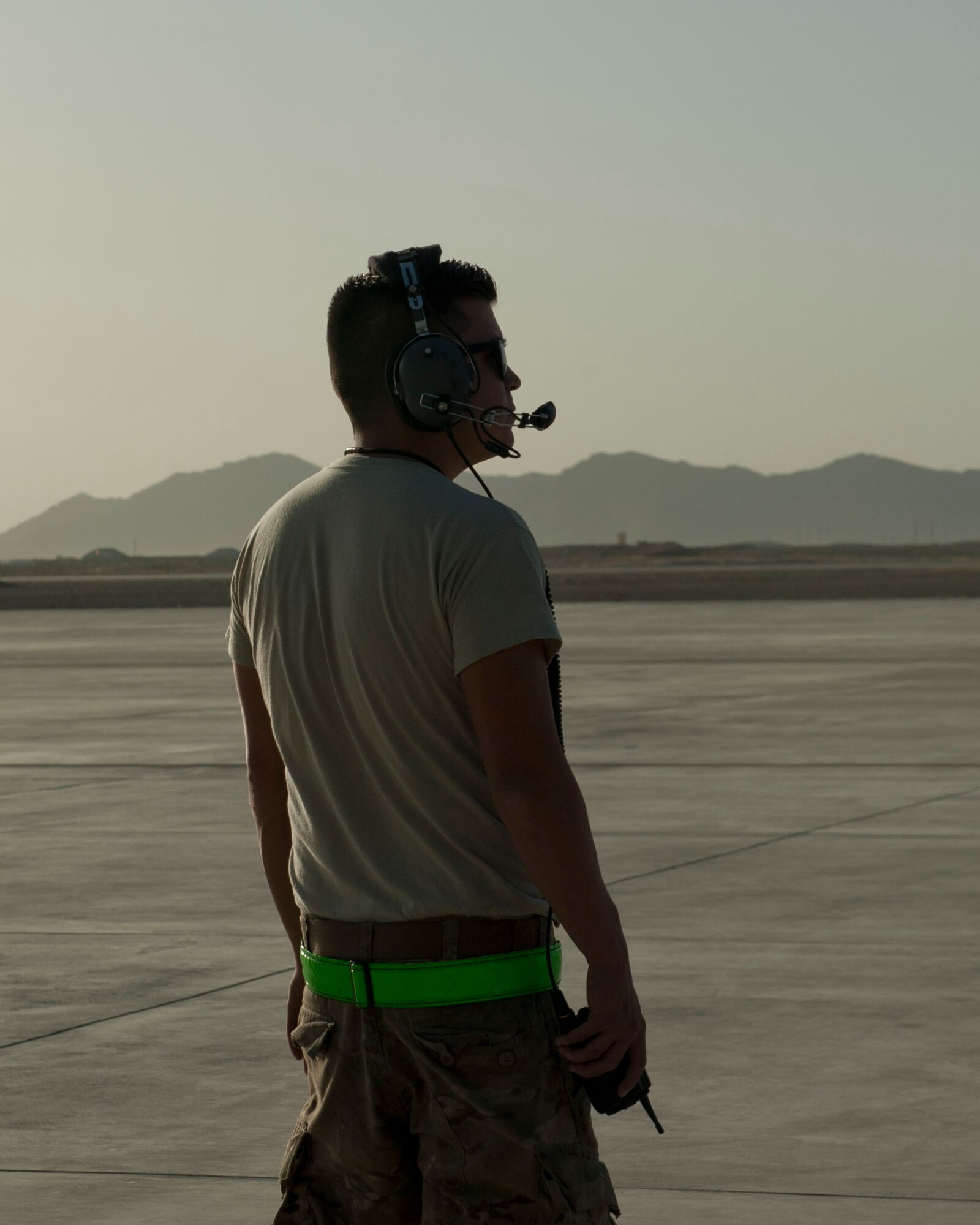 Staff Sgt. Patrick Brennan, 455th Expeditionary Aircraft Maintenance Squadron crew chief, looks towards a C-130J Super Hercules, Kandahar Airfield, Afghanistan, Aug. 19, 2016. Brennan was examining the C-130J as fuel was being uploaded to the aircraft for delivery to another base in Afghanistan. (U.S. Air Force photo by Capt. Korey Fratini)