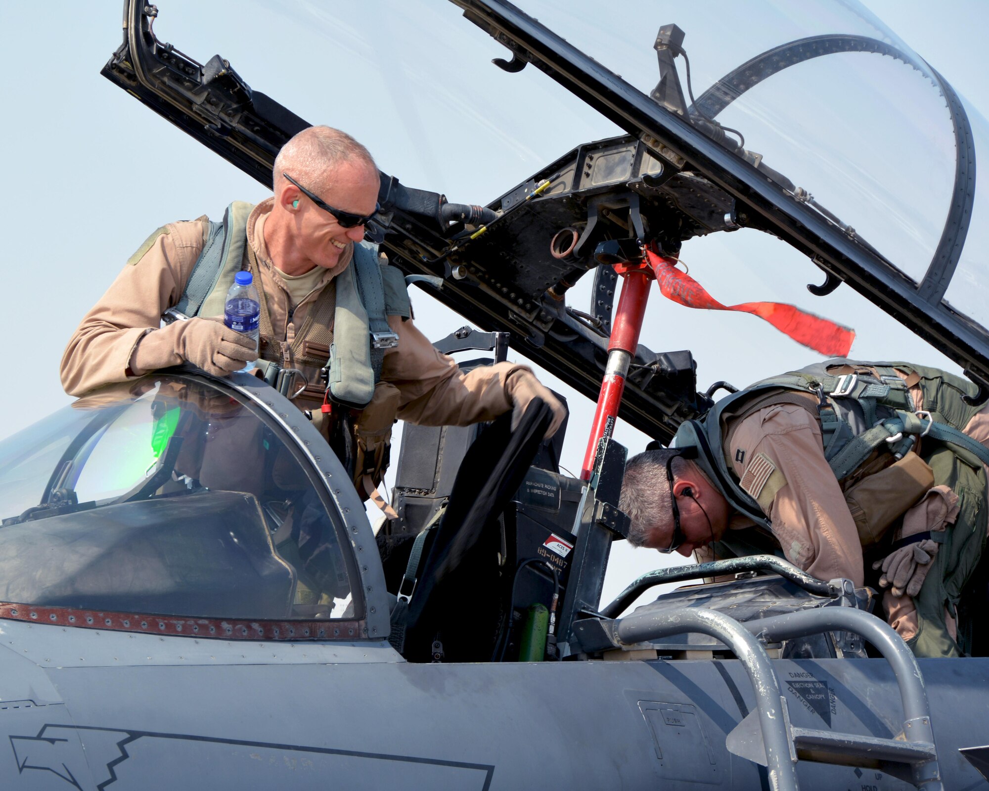 Lt. Col. Brandon, 335th Expeditionary Fighter Squadron commander, and Capt. Matthew, 335th Expeditionary Fighter Squadron weapon systems officer, prepare to disembark from F-15E Strike Eagle #89-0487 after a milestone flight at an undisclosed location, Aug. 16, 2016. The jet attained 12,000 flying hours and Brandon achieved 3,000 flying hours during the same flight. (U.S. Air Force photo by Staff Sgt. Samantha Mathison)