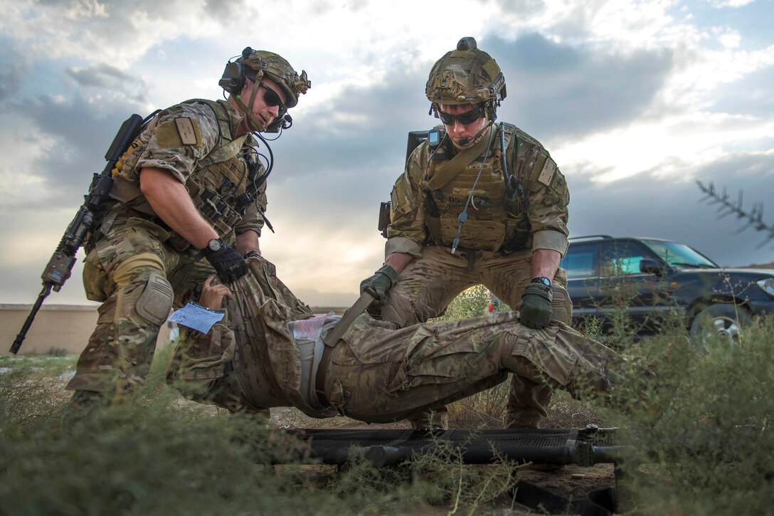 Air Force Senior Airmen Kyle Green, left, and Ty Hatcher place a simulated casualty onto a stretcher during a mass casualty and extraction exercise at Bagram Airfield, Afghanistan, Aug. 18, 2016. Green and Hatcher are pararescuemen assigned to the 83rd Expeditionary Rescue Squadron. Air Force photo by Senior Airman Justyn M. Freeman