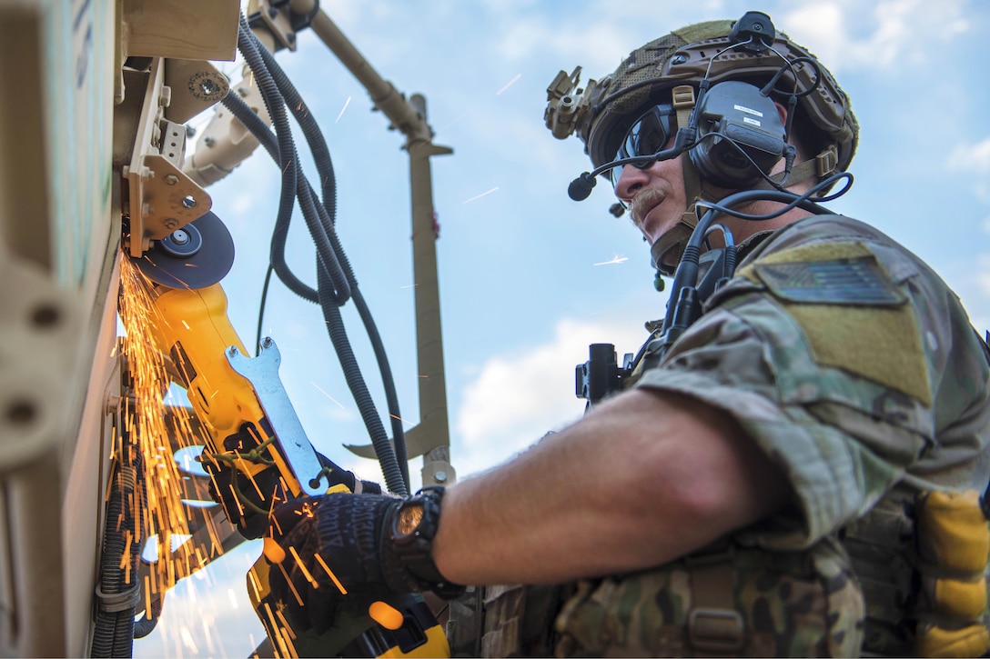 Air Force Senior Airman Kyle Green uses a circular saw to cut through the hinges on a mine-resistant, ambush-protected vehicle door during a mass casualty and extraction exercise at Bagram Airfield, Afghanistan, Aug. 18, 2016. Green is a pararescueman assigned to the 83rd Expeditionary Rescue Squadron. Air Force photo by Senior Airman Justyn M. Freeman