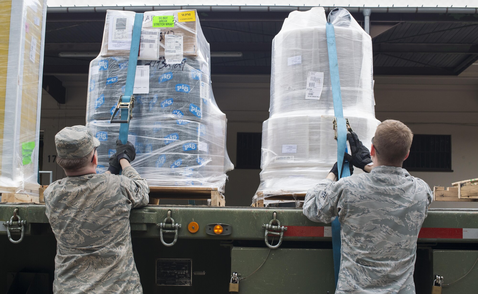 From left, Airman 1st Class Brody Ellyson and Senior Airman Joseph Clayson, 86th Vehicle Readiness Squadron vehicle operators, tie ratchet straps over cargo pallets Aug. 19, 2016 at Ramstein Air Base, Germany. It’s the responsibility of vehicle operators to transport people, supplies, munitions and outsized expeditionary forces. (U.S. Air Force photo/Senior Airman Tryphena Mayhugh)