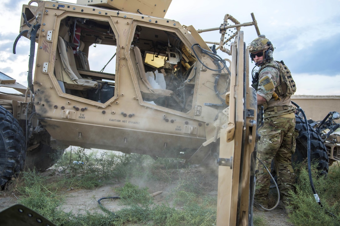 The door of a mine-resistant, ambush-protected vehicle rolls away as Air Force Senior Airman Kyle Green observes during a joint mass casualty and extraction exercise at Bagram Airfield, Afghanistan, Aug. 18, 2016. Green is a pararescueman assigned to the 83rd Expeditionary Rescue Squadron. Air Force photo by Senior Airman Justyn M. Freeman