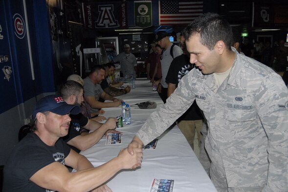 An airman from the 386th Air Expeditionary Wing shakes hands with Scotty 2 Hotty Aug. 10, 2016, during the Ringside Salute II tour at an undisclosed location in Southwest Asia. Scotty 2 Hotty and five other entertainers paid a visit to the base to thank deployed members for their service and sacrifices. (U.S. Air Force photo/Capt. Philip Cortez)