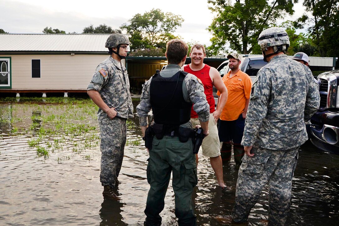 Soldiers and a civilian police officer check on residents in Crowley, La., Aug. 17, 2016. More than 30 inches of rainfall caused severe flooding in much of southeast Louisiana since Aug. 12. The soldiers are assigned to the Louisiana National Guard’s 3rd Battalion, 156th Infantry Regiment. Army National Guard photo by Sgt. Noshoba Davis