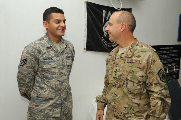 Lt. Gen. Jeffrey Harrigian, U.S. Air Forces Central Command commander, recognizes Staff Sgt. Victor Camacho, 386th Expeditionary Contracting Squadron, for his outstanding performance Aug. 20, 2016, at an undisclosed location in Southwest Asia. Harrigian made his first visit to the base after taking command of AFCENT last month. (U.S. Air Force photo/Senior Airman Zachary Kee)