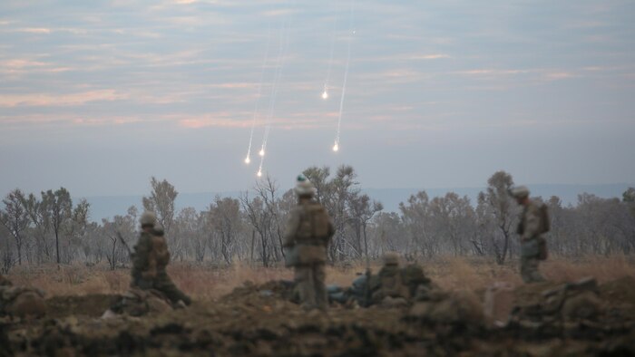 Marines with 1st Battalion, 1st Marine Regiment, watch illumination from artillery fall to the ground during a live fire range August 18, 2016, at Bradshaw Field Training Area, Northern Territory, Australia. The range was the final training evolution of Exercise Koolendong 16, a trilateral exercise between the U.S. Marine Corps, Australian Defence Force and French Armed Forces New Caledonia. Marines held a defensive position while engaging targets and working through the CS gas, which simulated a chemical attack.