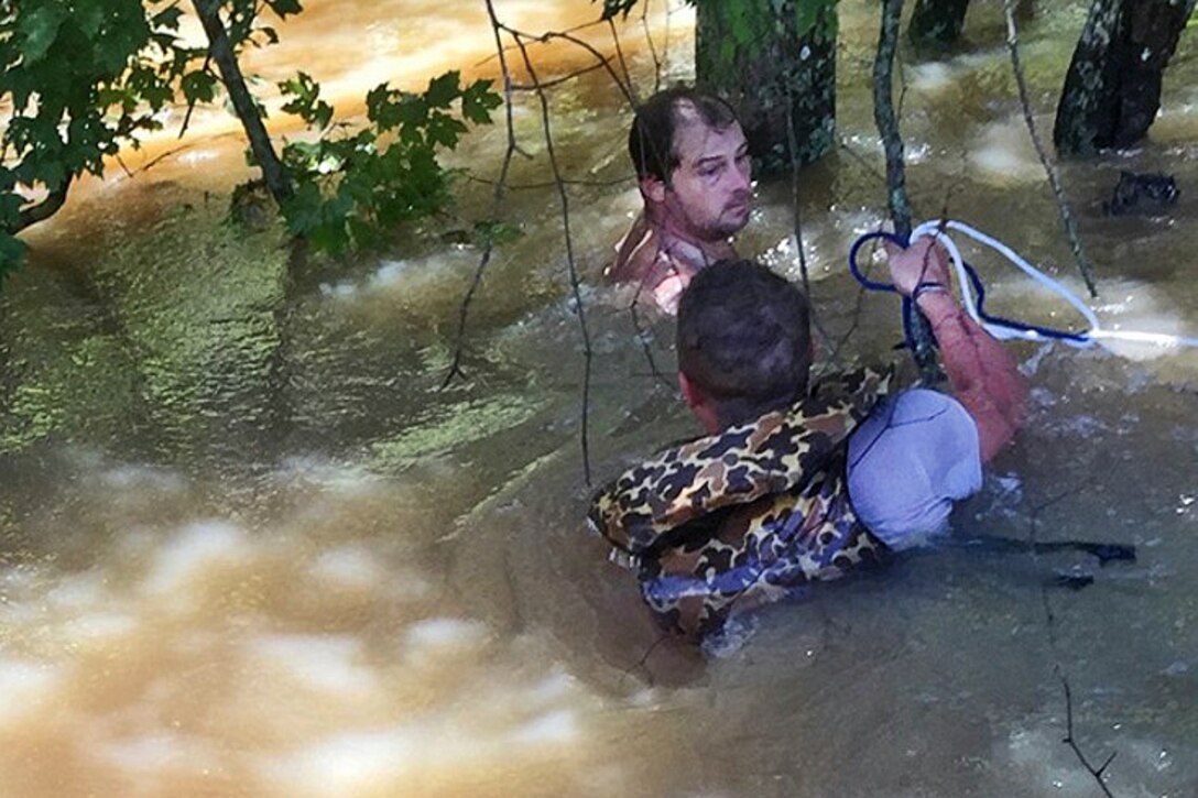 Army Sgt. P.J. Freeman works to rescue a citizen whose boat had capsized in fast-moving floodwaters in Livingston Parish near Baton Rouge, La., Aug. 16, 2016. Freeman and Sgt. Jared LeBlanc, both assigned to the Louisiana Army National Guard’s 922nd Engineer Company, 769th Brigade Engineer Battalion, rescued the citizen while performing search-and-rescue duties near Highway 16. Army National Guard photo by Spc. Miguel Toefiel