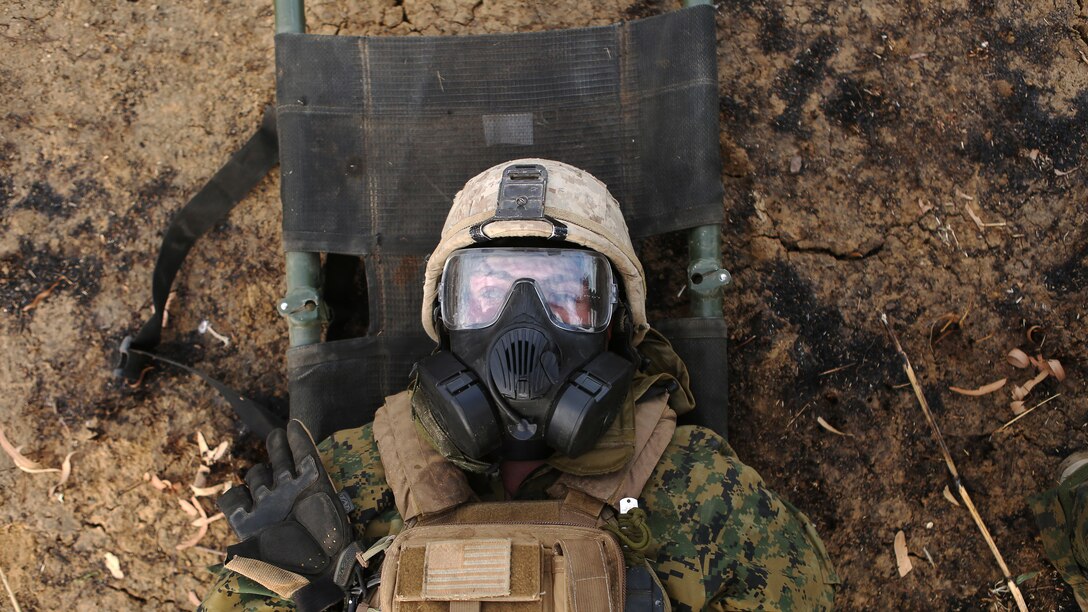 A simulated casualty lays on a litter before a decontamination process after a CS gas attack August 18, 2016, at Bradshaw Field Training Area, Northern Territory, Australia. The Marine took part in the final  live fire range of Exercise Koolendong 16, a trilateral exercise between the U.S. Marine Corps, Australian Defence Force and French Armed Forces New Caledonia. Marines held a defensive position while engaging targets and working through the CS gas, which simulated a chemical attack.