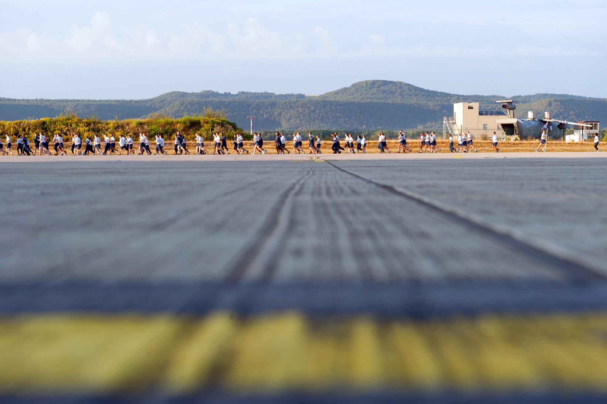 Airmen run the flightline during a tri-wing run Aug. 18, 2016, at Ramstein Air Base, Germany. The tri-wing run included Airmen from the 86th Airlift Wing, 435th Air Ground Operations Wing and 521st Air Mobility Operations Wing. The event aims to promote camaraderie and physical fitness. (U.S. Air Force photo/Staff Sgt. Sharida Jackson)