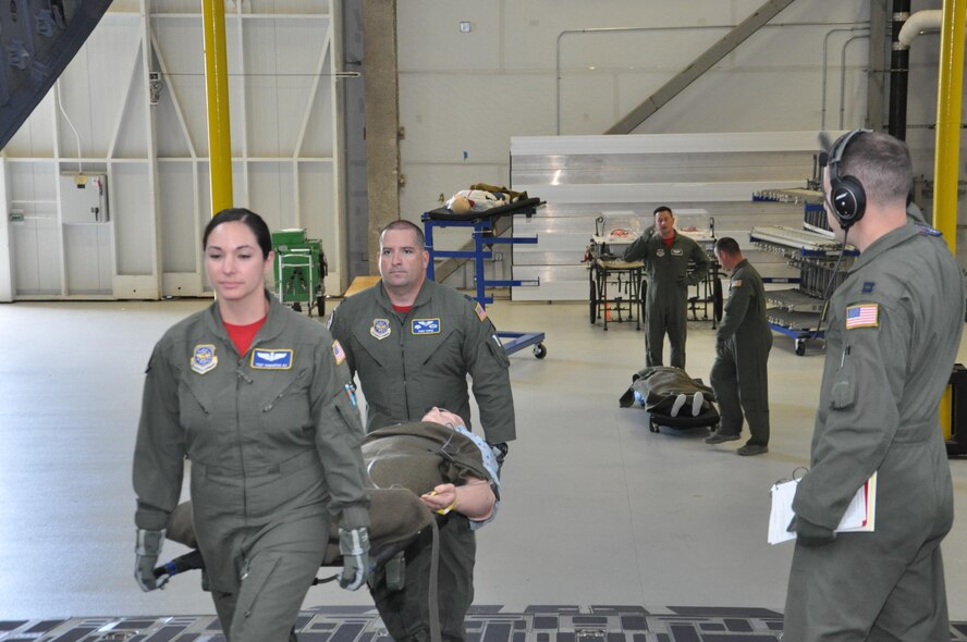 Litter bearers, Tech. Sgt. Samantha Au and Capt. Diego Torres, load a simulated patient aboard a C-17 Globemaster III aeromedical trainer under the direction of Capt. Andrew Meidlinger, Flight Nurse Instructor, during a training demonstration. All three Airmen are assigned to the 375th Operations Group, Detachment 4 (AMC), a geographically-separated formal training unit at Wright-Patterson Air Force Base, Ohio. Det. 4 is a part of Scott AFB’s 375th Air Mobility Wing. The FTU provides qualification training for all Reserve, guard, and active duty flight nurses and aeromedical evacuation technician in aeromedical evacuation support, deployment, humanitarian and global response scenarios for their students.