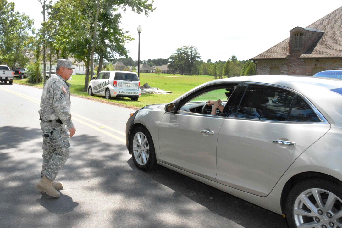 Army Sgt. David J. McGarrity provides directions to a driver in Denham Springs, La., Aug. 19, 2016. McGarrity, a police officer assigned to the Louisiana National Guard's 39th Military Police Company, 773rd MP Battalion, 139th Regional Support Group, was conducting a roving patrol of the area for residents' safety and security in the wake of severe flooding. Army National Guard photo by Staff Sgt. Scott D. Longstreet