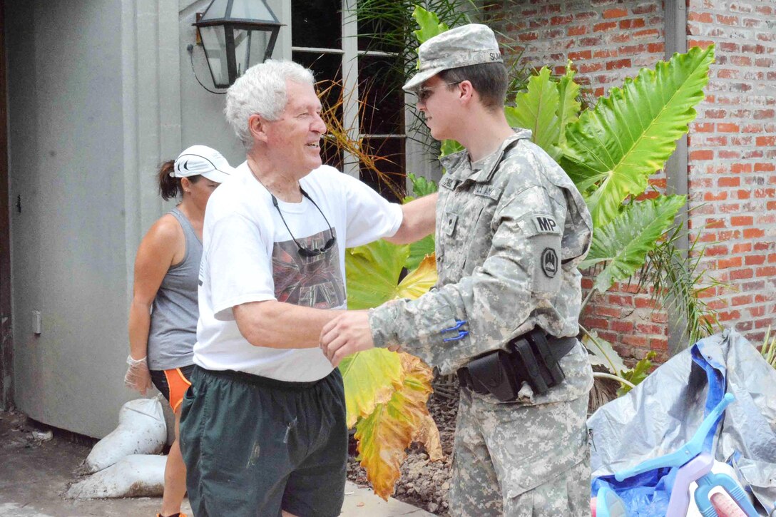 Army Spc. David A. Summers, right, talks to Kenneth Gaddis, a resident of the Greystone Subdivision in Denham Springs, La., Aug. 19, 2016. Summers, a police officer assigned to the Louisiana National Guard's 39th Military Police Company, 773rd MP Battalion, 139th Regional Support Group, was conducting a roving patrol of the flood-stricken area for residents' safety and security. Army National Guard photo by Staff Sgt. Scott D. Longstreet