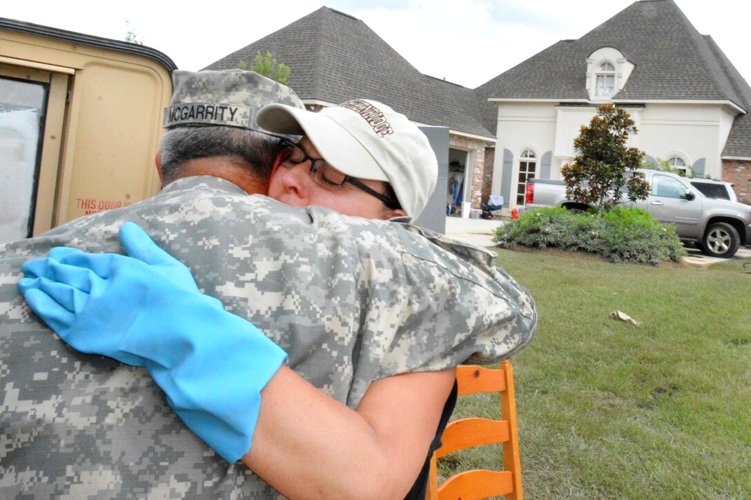 Army Sgt. David J. McGarrity, left, receives a hug from a resident in flood-stricken Denham Springs, La., Aug. 19, 2016. McGarrity is a police officer assigned to the Louisiana National Guard's 39th Military Police Company, 773rd Military Police Battalion, 139th Regional Support Group. Army National Guard photo by Staff Sgt. Scott D. Longstreet