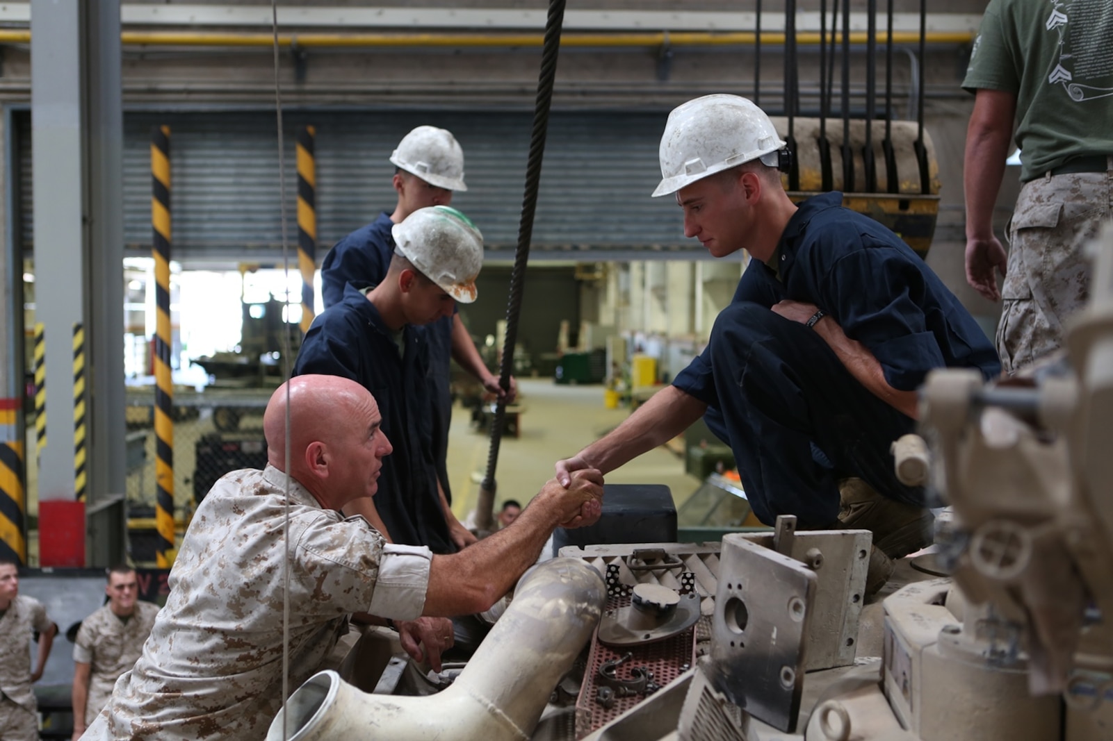U.S. Marine Brig. Gen. David A. Ottignon greets and presents a challenge coin to Lance Cpl. Michael Hamilton, a tank mechanic from Combat Logistics Company 13, Combat Logistics Regiment 15, 1st Marine Logistics Group, at Marine Corps Air Ground Combat Center Twentynine Palms, Calif. Aug. 12, 2016. Ottignon is the 1st MLG commanding general. The MLG commanding general, sergeant major, and command master chief visited the combat center to speak with unit commanders as well as engage junior Marines and non-commissioned officers to get a sense of how MLG units are doing and what areas could be improved upon. (U.S. Marine Corps photo by Sgt. Carson Gramley/released)