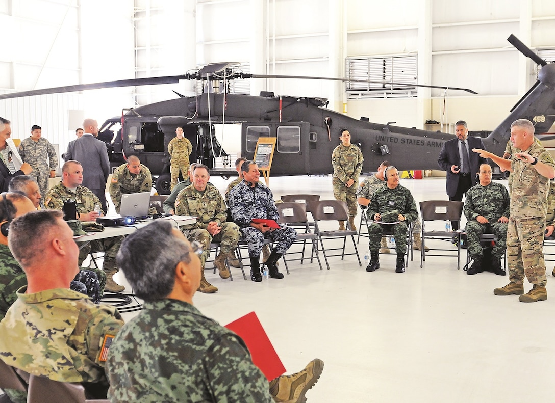 Maj. Gen.  Wayne W. Grigsby Jr., commanding general of the 1st Infantry Division and Fort Riley, provides an overview of 1st Combat Aviation Brigade, 1st Inf. Div., capabilities to the Fifth Army Inter-American Relations Program delegation on July 21 at Fort Riley. The delegation, led by Lt. Gen. Perry L. Wiggins, commander of U.S. Army North, and the Mexican air force Lt. Gen. Miguel Vallin, looked at aircraft and learned about the maintenance necessary to maintain the unit’s readiness.